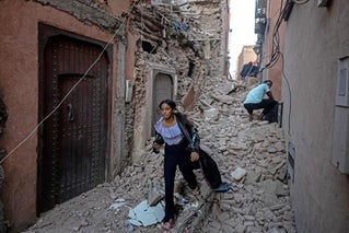 woman walking through rubble