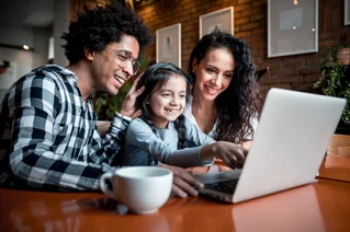 Happy family using a laptop in a cafe