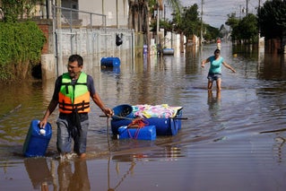locals wading through brazil flooding 2024