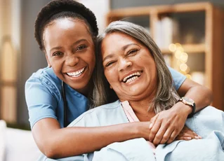 elder woman hugged by younger woman