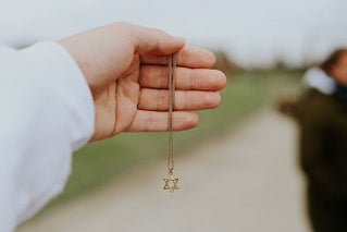 hand holding Star of David necklace