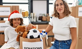 woman and child in santa hats next to donations
