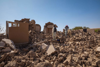 two people walking through rubble