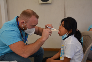 volunteer doctor examining child
