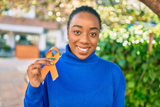 smiling woman holding orange ribbon