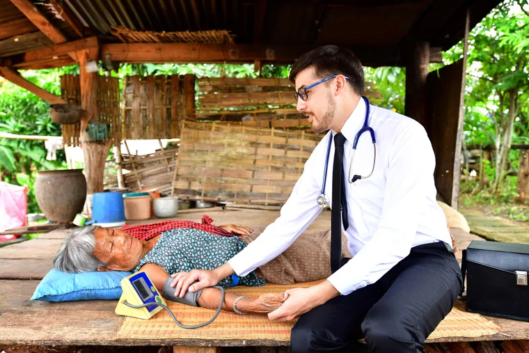 Doctor in a tropical setting, treating a patient