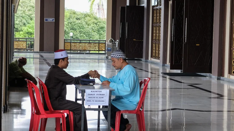 An image of two gentlemen holding hands from across the table in gratitude