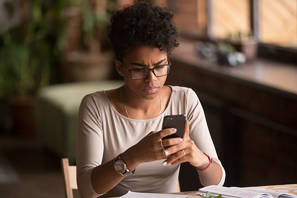 A young person looking at her phone, concerned