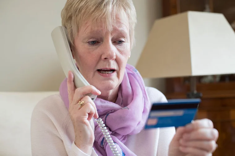 A woman on her phone asks a charity questions about their organization before donating
