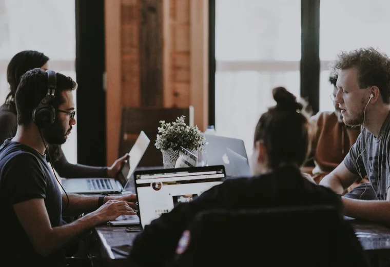 A group of employees work together at a meeting table