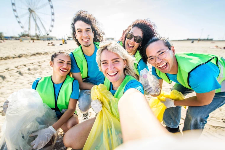 Group of young volunteers smiling during a beach cleanup