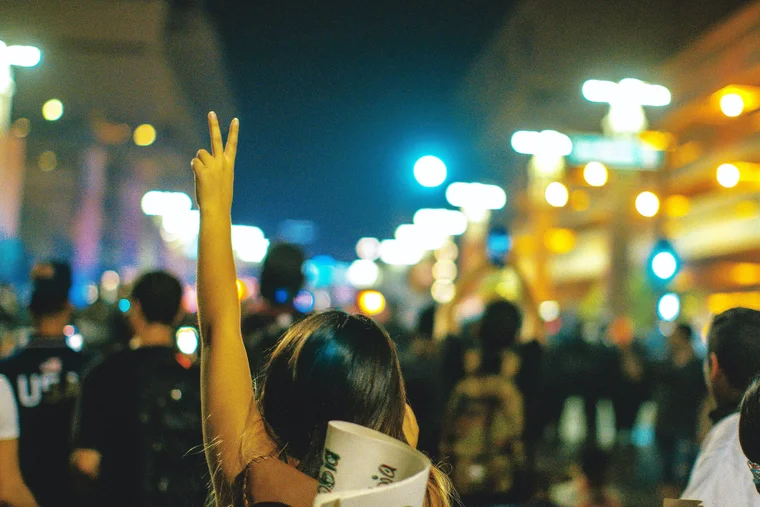 peace sign in crowded night street