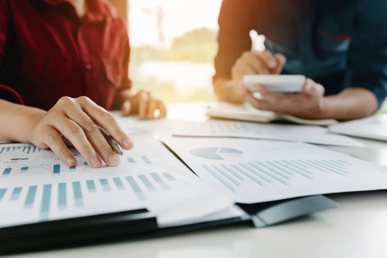 Close up of people going over data on paper
