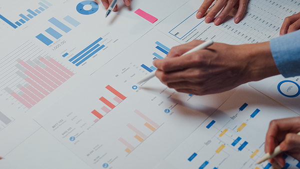 team of workers looking over business charts statistics
