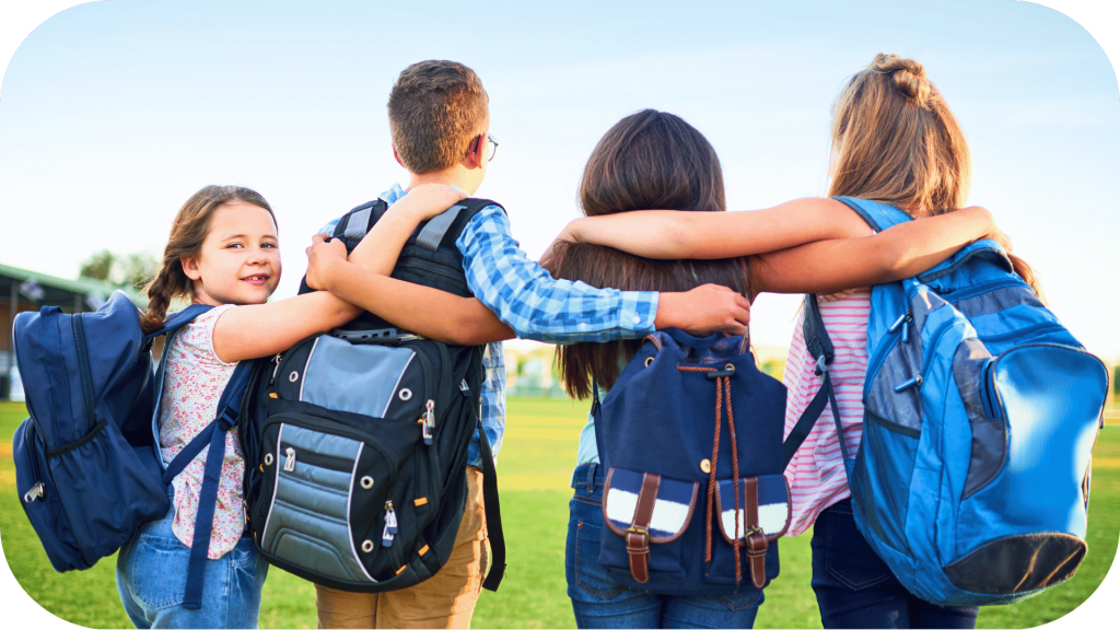 Kids with backpacks, wrapping their arms around each other's shoulders. One child is looking at the camera, smiling
