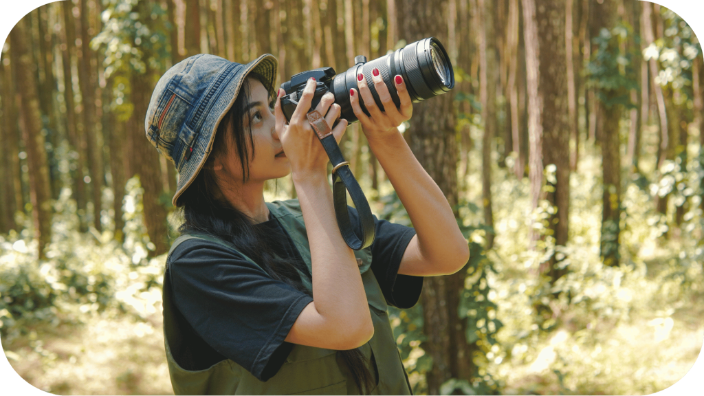 Woman in a forest, taking photos of wildlife